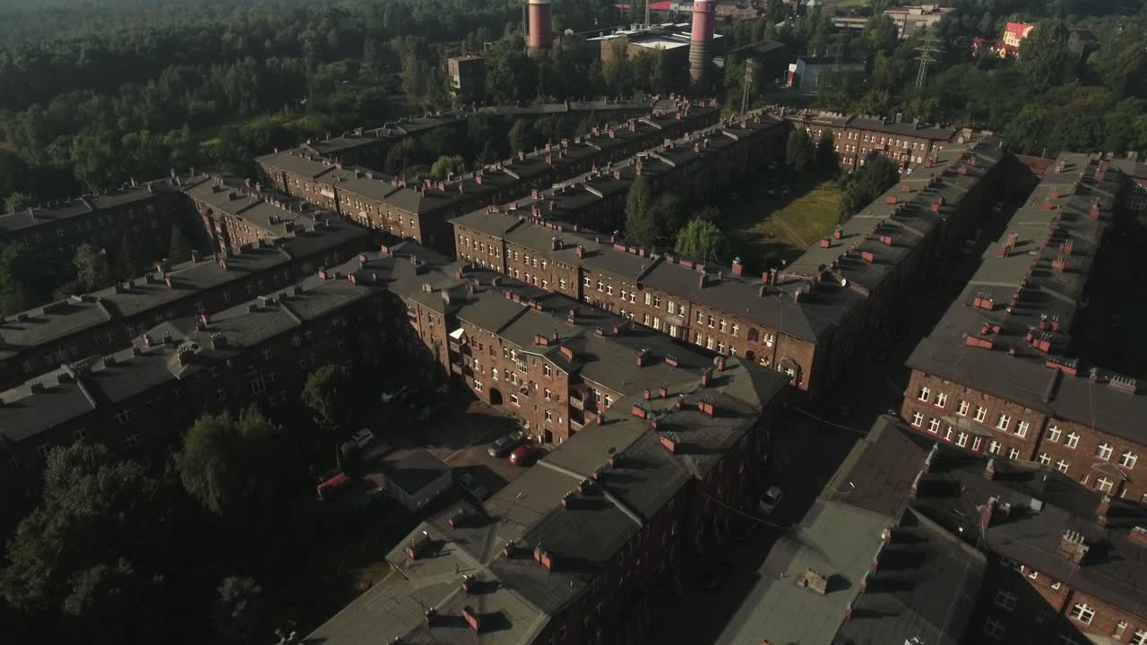 은 벽돌로 된 역사적인 노동자 정착촌인 니키소비체 (nikiszowiec) 는 은 여름날에 푸른 나무와 잔디을 가지고 있습니다.