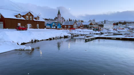 calm rippling waters in husyavic harbor with norã°urã¾ing municipal church in winter time