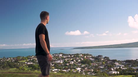 slowmo - young caucasian tourist looking at the ocean from mount victoria, auckland, new zealand