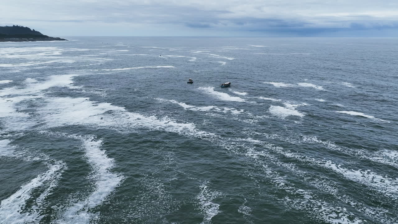 Aerial view rising toward whale watching boats on the coast of cloudy Oregon, USA