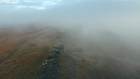 grandes acantilados rocosos desnudos, afloramiento con pequeña niebla blanca densa y nubes grises