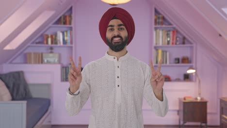 happy sikh indian man showing victory sign