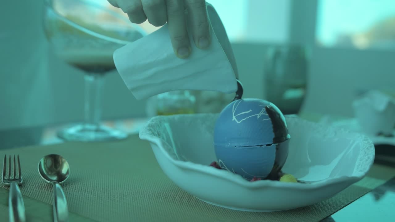 derritiendo una bola de soufflé con chocolate caliente, en un restaurante bajo el agua en las maldivas