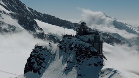 slow circling shot of jungfraujoch with clouds and peaks