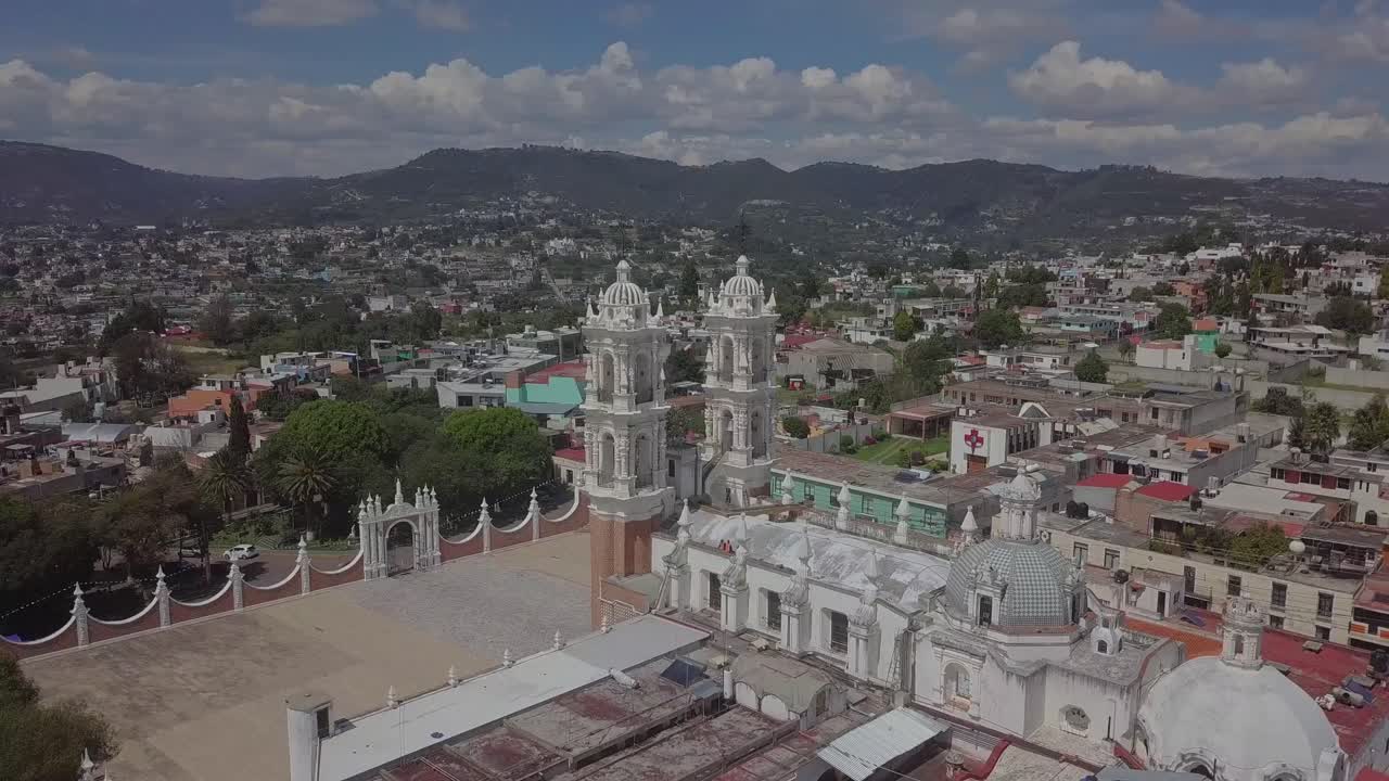 Drone orbit capturing the Basilica of Ocotlán and its iconic white towers. Shot in 4K with clear skies in Tlaxcala, Mexico