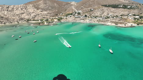 boats driving fast off the beach in paros, greece