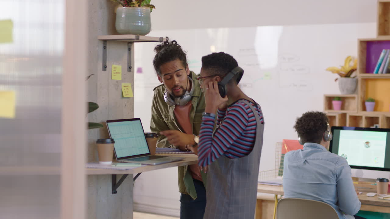 young business people brainstorming mixed race team leader man showing support helping colleague sharing ideas enjoying teamwork using laptop computer in modern office