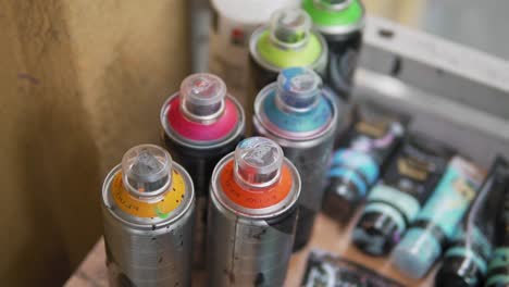 Colorful-spray-painting-bottles,-graffiti-and-street-art-concept