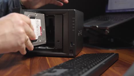 persona insertando un disco duro en una pequeña redada de computadora negra