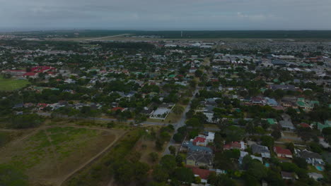 Fly-above-family-houses-in-urban-borough-on-town-outskirts.-Aerial-panoramic-view-of-residential-satellite.-Port-Elisabeth,-South-Africa