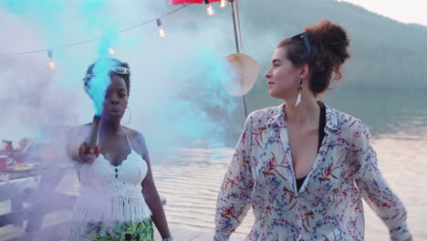 happy friends dancing with colored smoke bombs outdoors