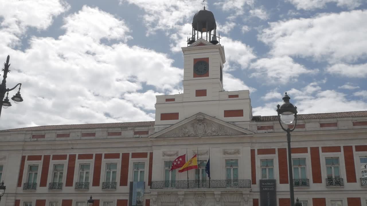 Puerta del Sol, iconic square in Madrid, showing its historic clock tower and vibrant flags