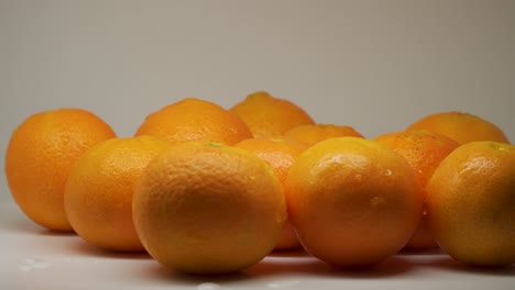 Group-Of-Fresh-Juicy-Orange-On-The-Turntable-With-White-Background---Close-Up-Shot