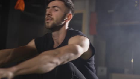 hombre barbudo entrenando en el gimnasio con una máquina de remo