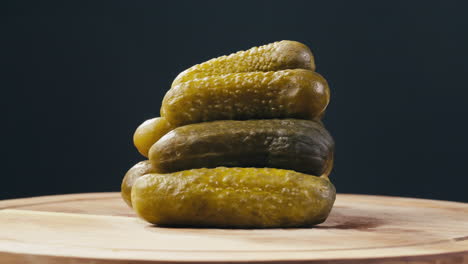 stacked pickles on wooden cutting board