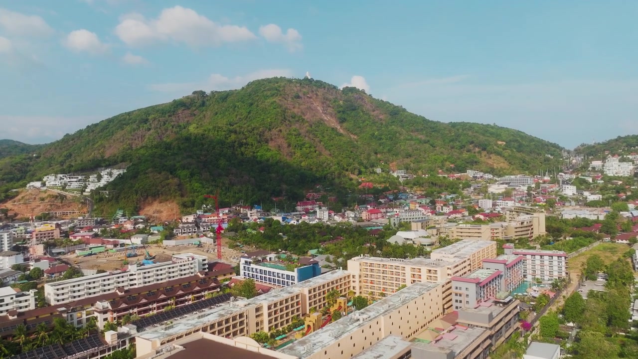 Máy bay không người lái bay lên trên thị trấn nghỉ dưỡng Patong hướng về ngọn đồi nhiệt đới tươi tốt ở Phuket, Thái Lan.