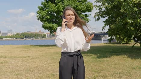 Frau-Spricht-über-Ihr-Smartphone,-Während-Sie-Unter-Der-Sonne-Handgesten-Macht,-Statische-Nahaufnahme