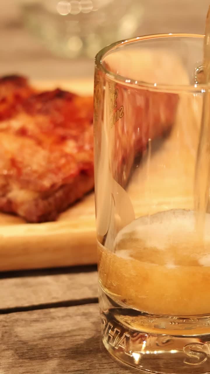 Birra versata in un bicchiere accanto a deliziose costine