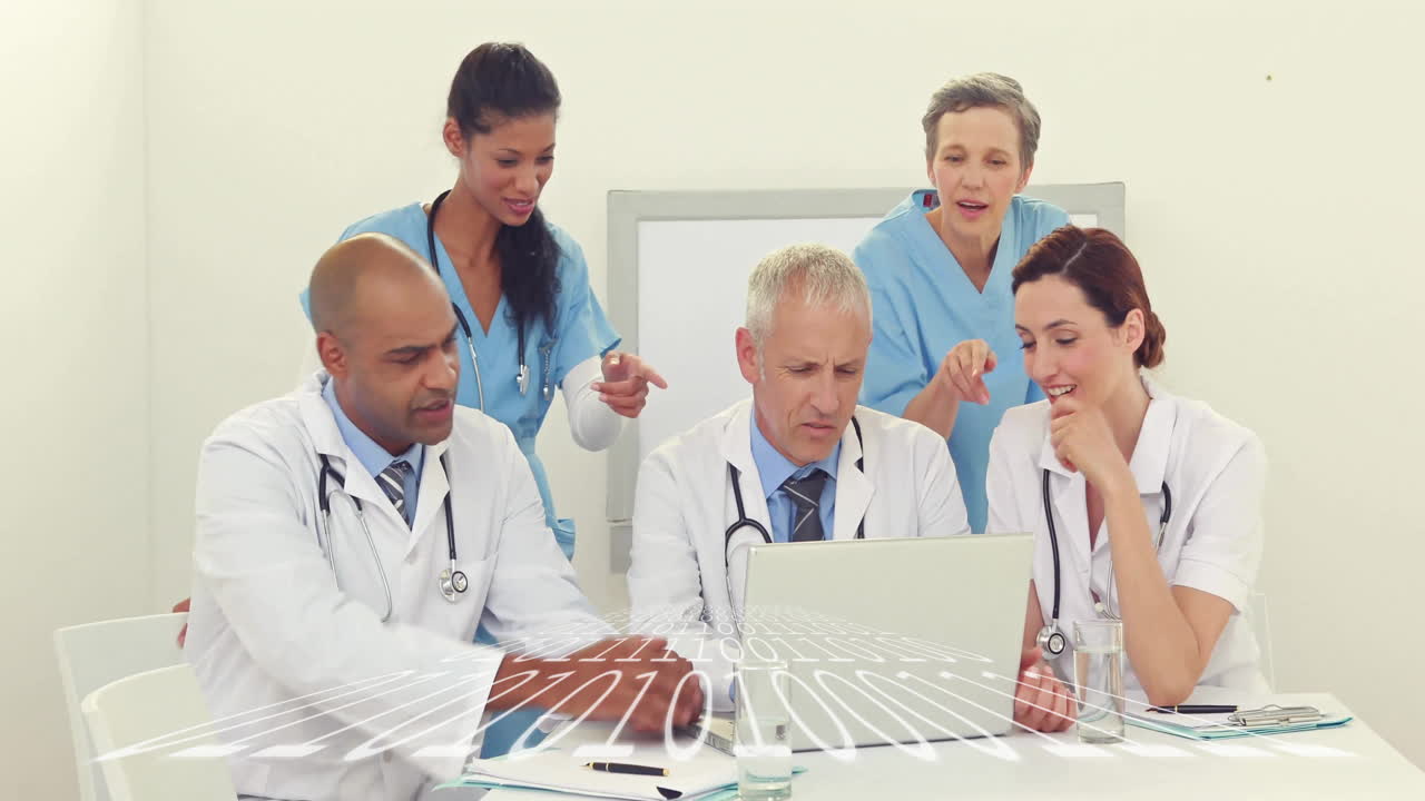 Medical team collaborating around laptop, displaying animated patient chart and floating heart icon