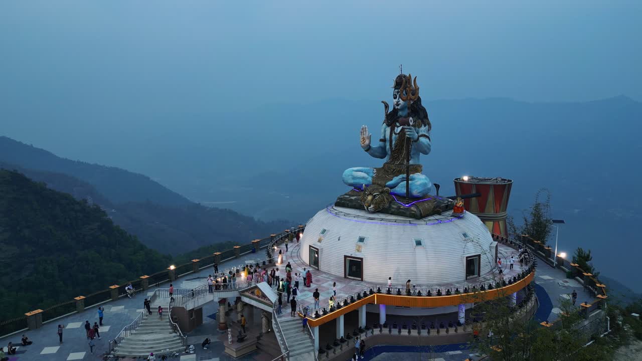 la retirada del avión no tripulado revela montañas de niebla azul detrás de la estatua de shiva en pumdikot, nepal.