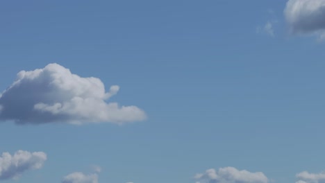 Filmen-Mit-Einer-Drohne-In-70-Mm-Den-Durchgang-Wunderschöner-Weißer-Wolken-Mit-Schatten-In-Den-Unteren-Teilen-In-Einem-Auffallend-Blauen-Himmel-Mit-Seinen-Eigentümlichen-Baumwollformen.-Die-Aufnahme-Ist-Entspannend-Und-Ruhig