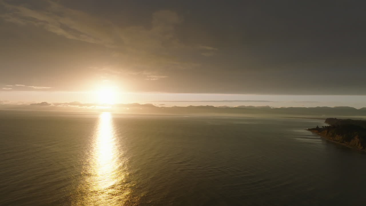 태즈만 만을 가로질러 미끄러지는 무인기의 사진으로 뉴질랜드의 해안선을 보여줍니다.