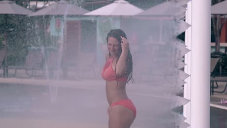 happy-woman-runs-through-arch-with-water-jets-slow-motion