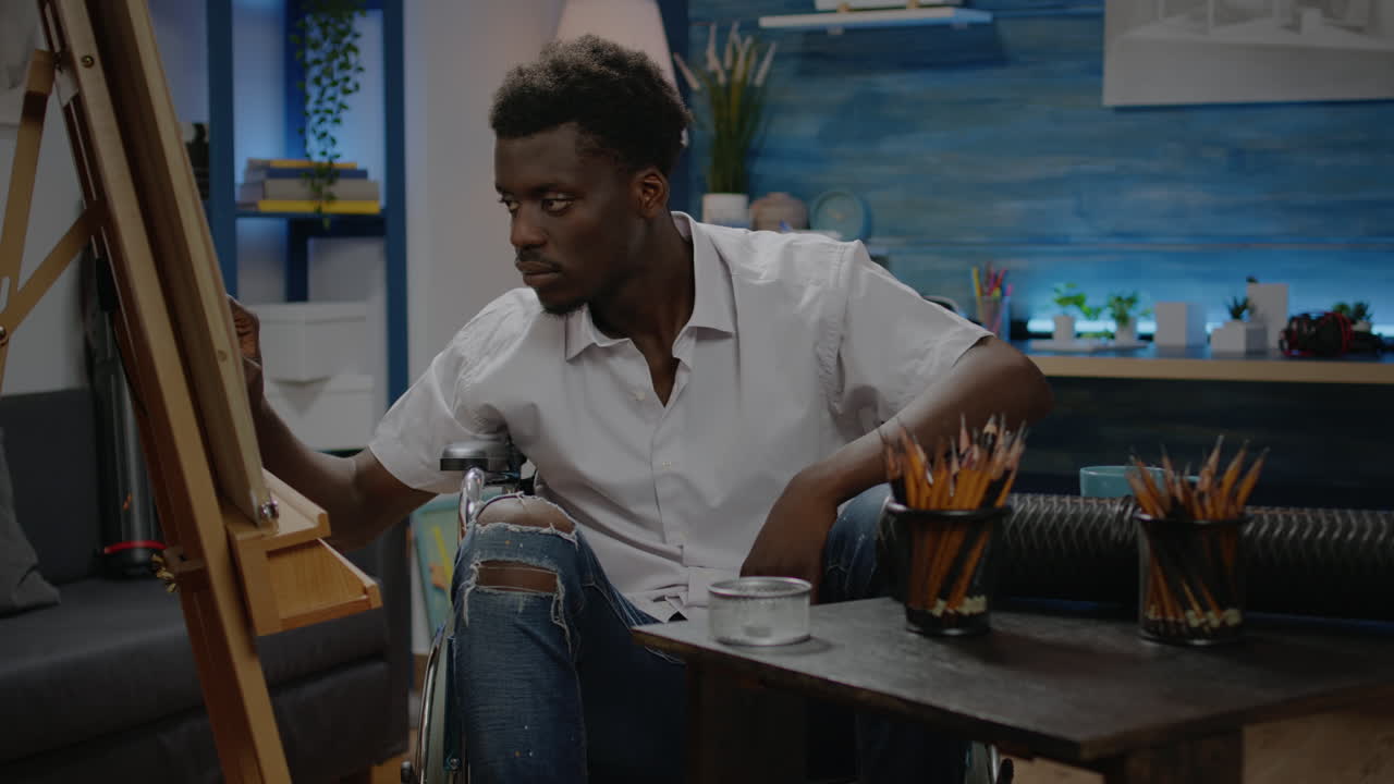 African american man sitting in wheelchair while drawing