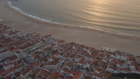 imágenes de drones de la ciudad de nazare en la costa de portugal filmadas durante la hora dorada del atardecer 4k