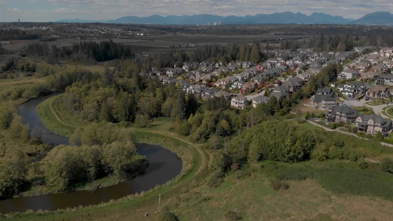 Drone 4K-opptak av Cloverdale byboliger for middelklasseborgere, regulert byplanlegging nær en beskyttet bekk for flora og fauna