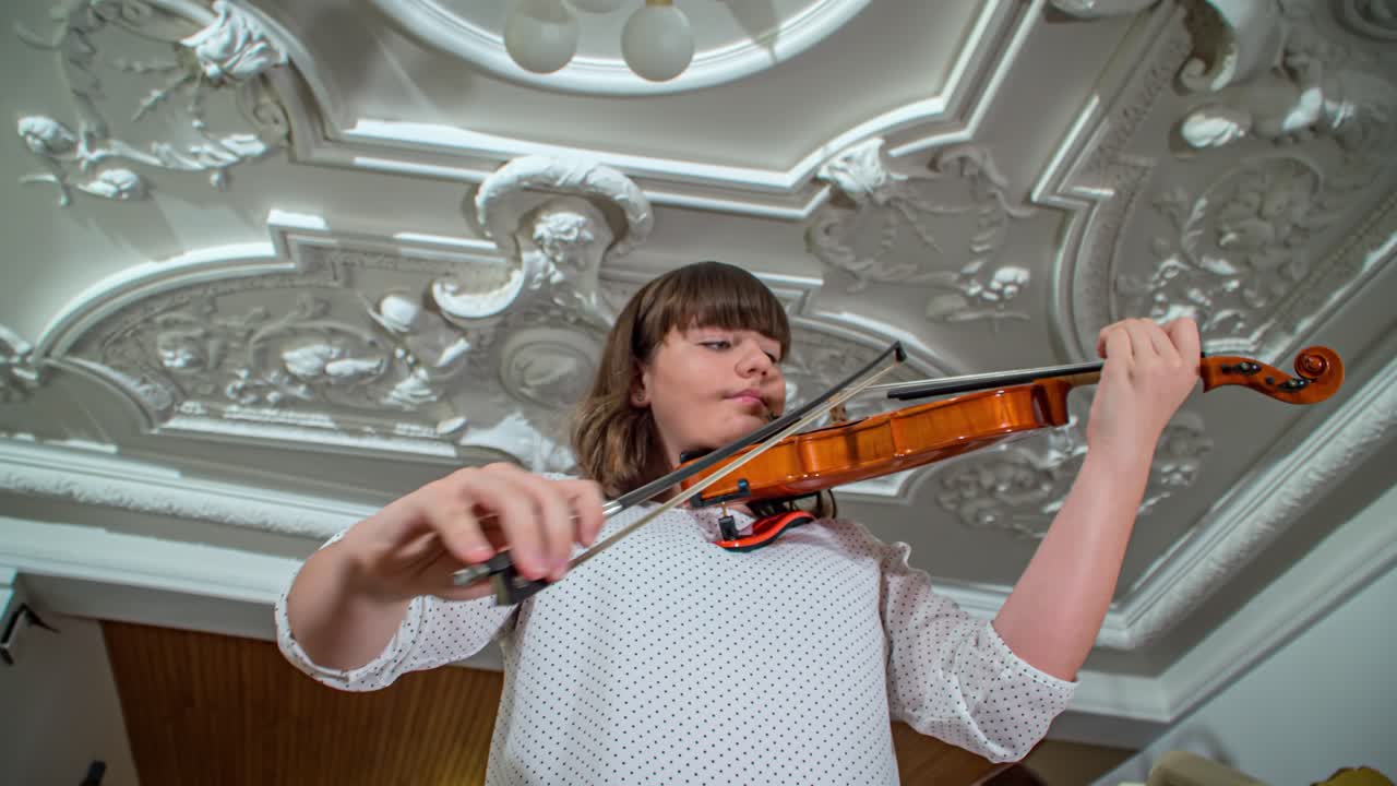 Violinist playing chords with passion indoors