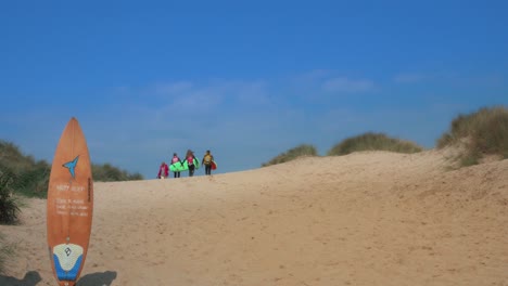 Surfers-heading-over-horizon-towards-beach-on-sunny-day