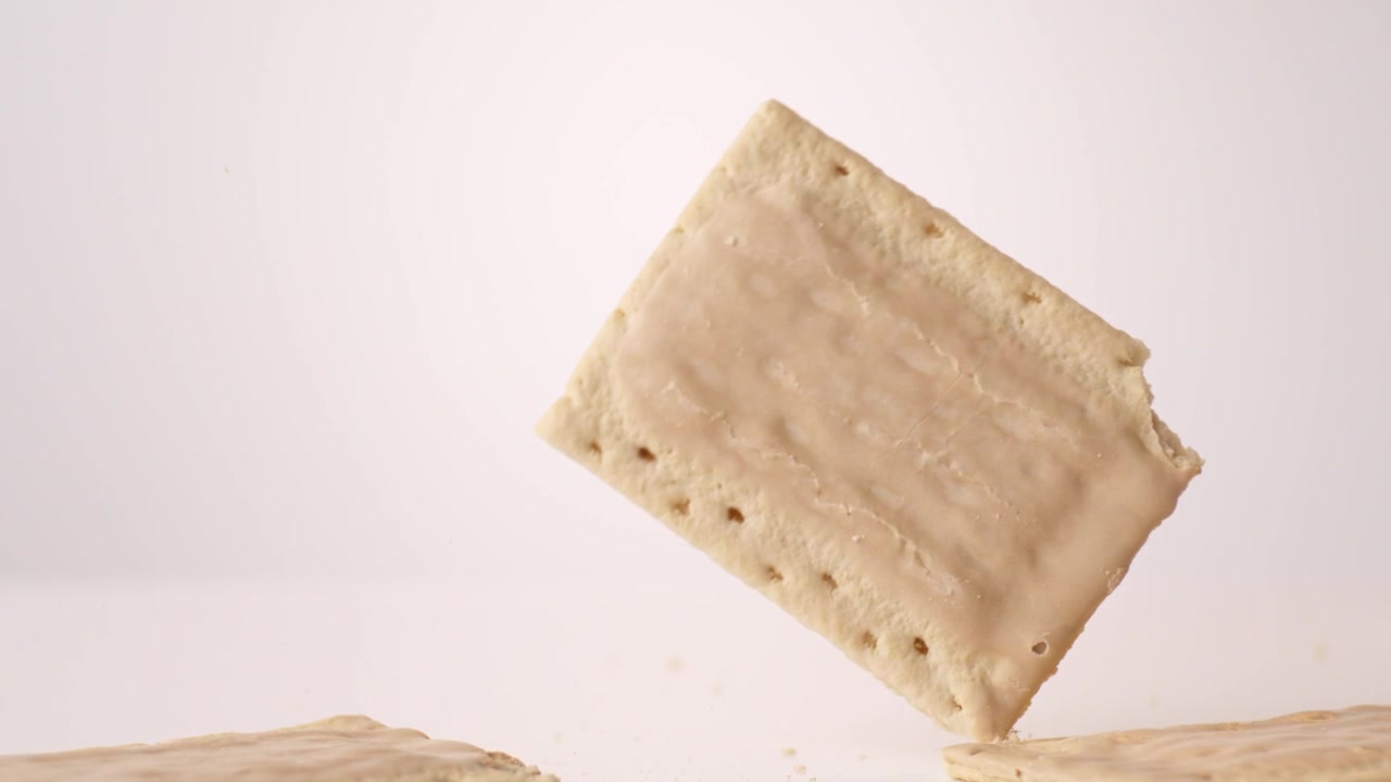 Cinnamon-frosted retro pop tarts dropping and bouncing across white seamless backdrop in high speed slow motion. back to school posts, after school snack videos, kids brand commercials.