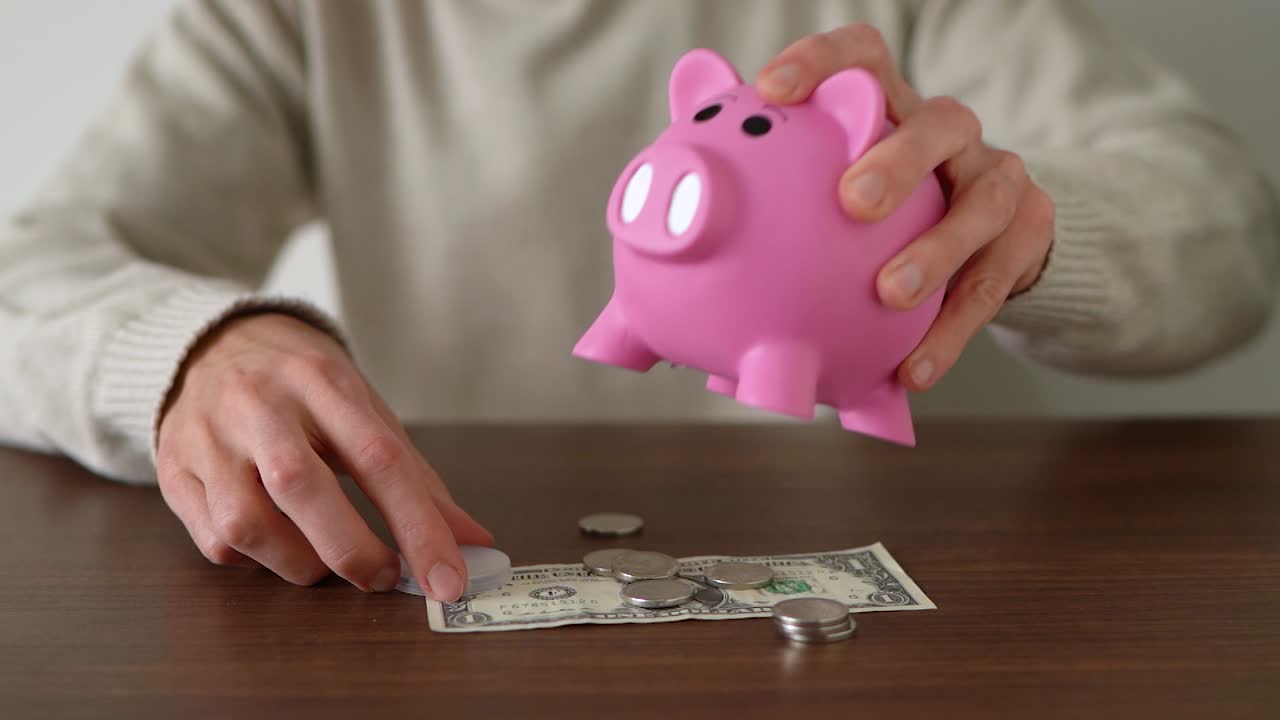 Person withdrawing coins from the piggy bank
