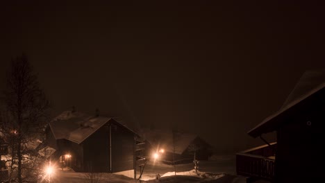 beautiful time lapse of houses being overwhelmed by snowstorm, traffic passing through village, panning view from left to right