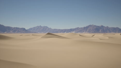 vasto paisaje desértico con dunas de arena y montañas en la distancia