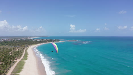 aerial - parasailing in porto de galinhas beach, ipojuca, brazil, reverse tracking