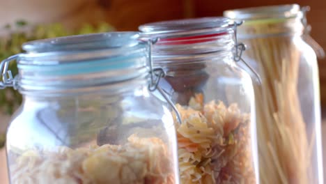 Storage-jars-of-food-on-countertop-in-sunny-kitchen,-slow-motion