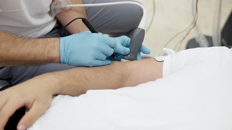 Patient-Liegt-Mit-Akupunkturtechnik-Auf-Dem-Arm,-Muskelstimulationstechnik
