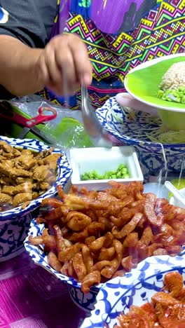 vendor serving shrimp paste rice at bangkok floating market stall