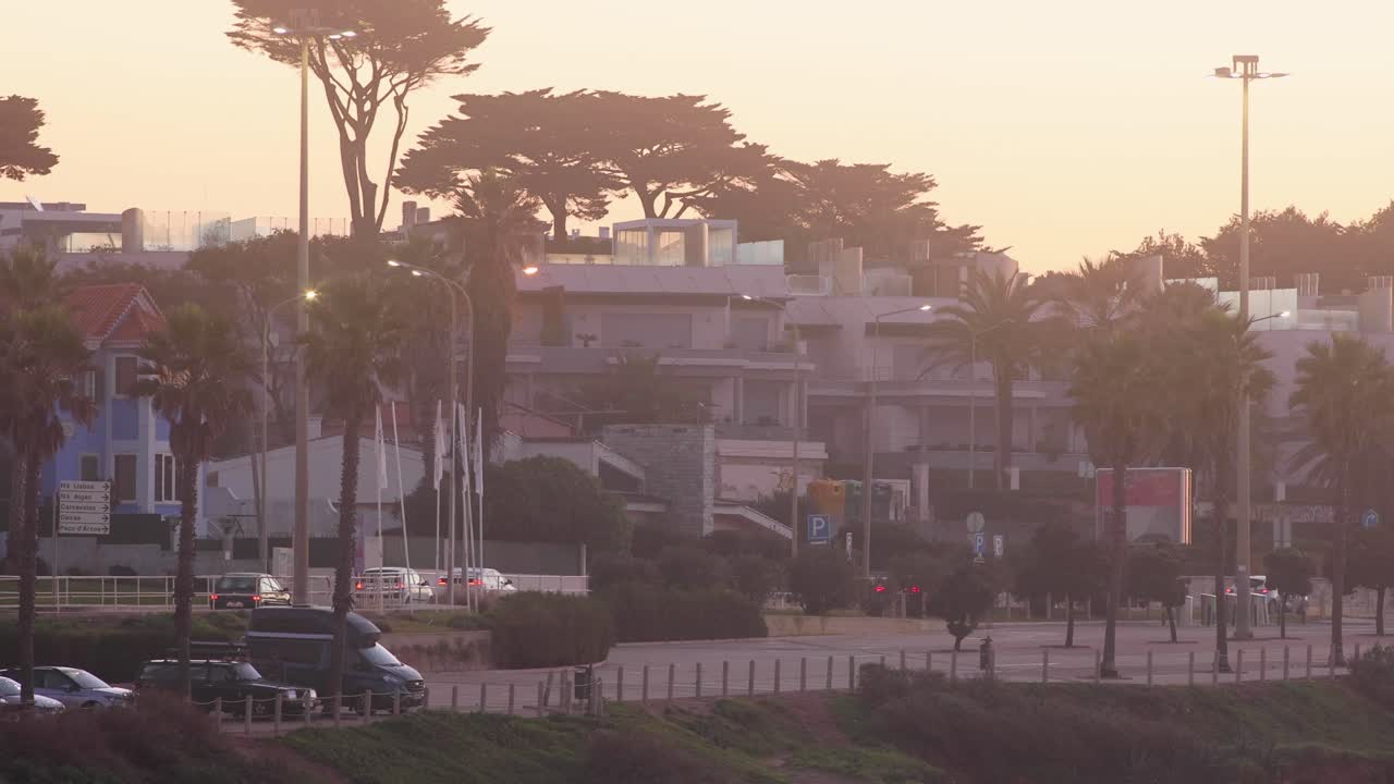 silueta de la ciudad al fondo del atardecer con algunos autos circulando cerca de cascais