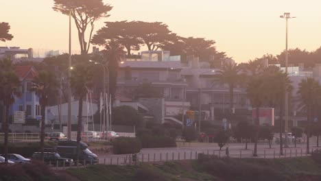 Silueta-De-La-Ciudad-En-El-Fondo-Del-Atardecer-Con-Algunos-Autos-Conduciendo-Cerca-De-Cascais