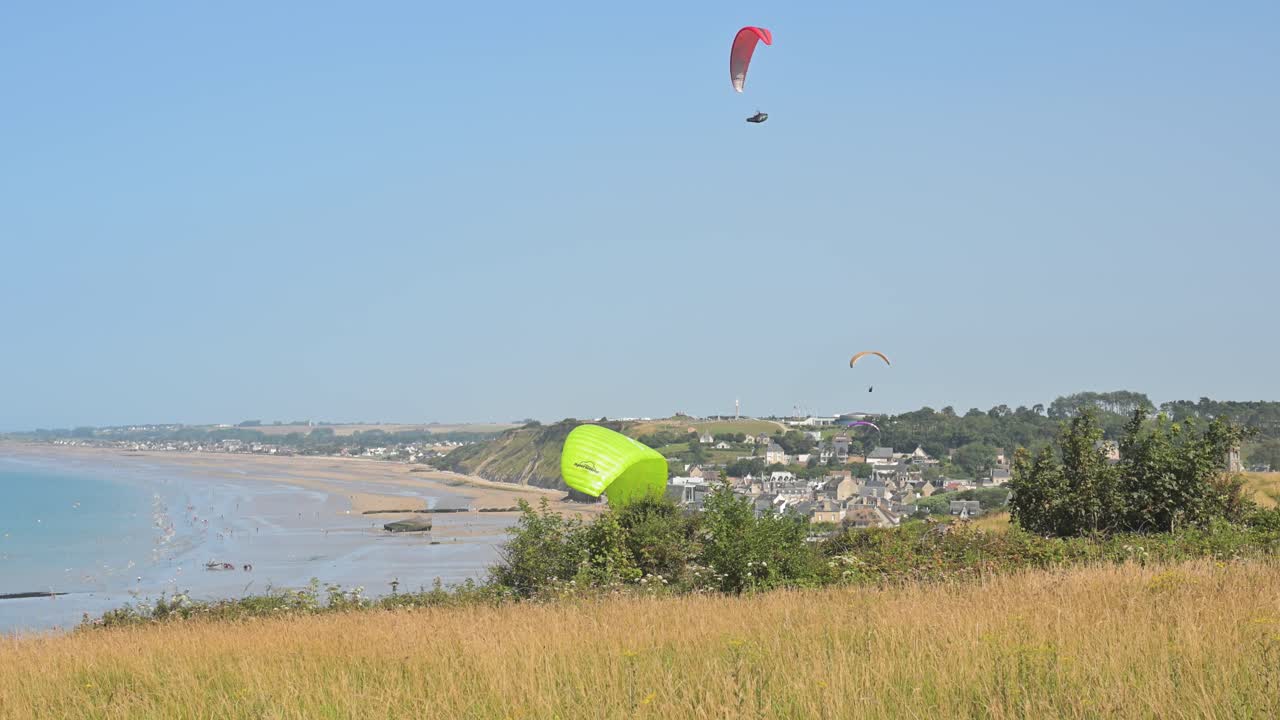 Paraglidingudstyr udlagt på klipperne ved Arromanches