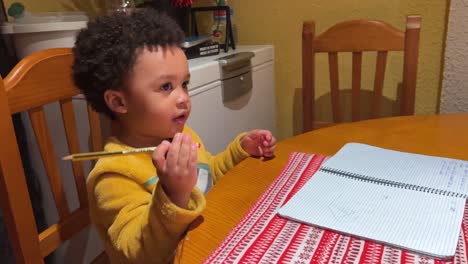 Two-year-old-exotic-back--baby-draws-in-a-notebook