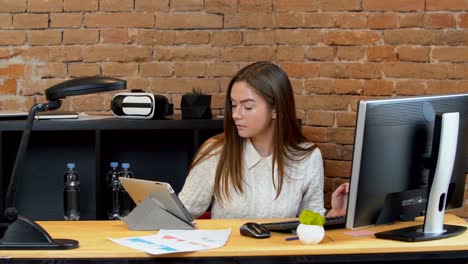 close up of a beautiful young woman scrolling her tablet computer on the office.