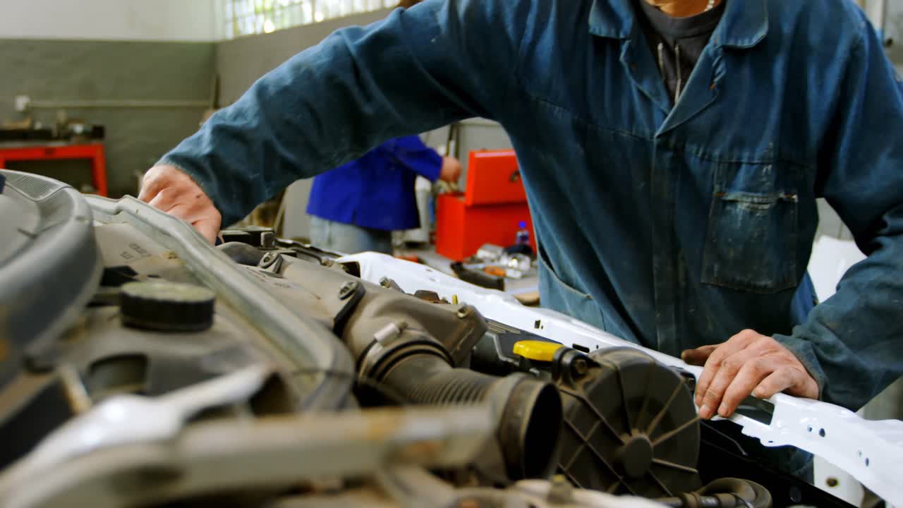 mecánico examinando un coche 4k