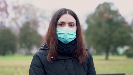 Young-woman-looking-at-the-camera-while-wearing-a-protective-mask-Covid--19,-Corona-virus-protection