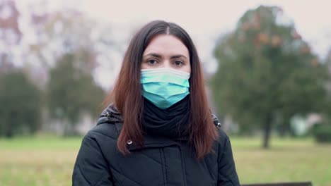 mujer joven mirando la cámara mientras usa una máscara protectora covid -19, protección contra el virus de la corona