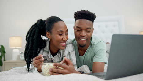 Popcorn,-bed-and-couple-on-laptop-for-movie