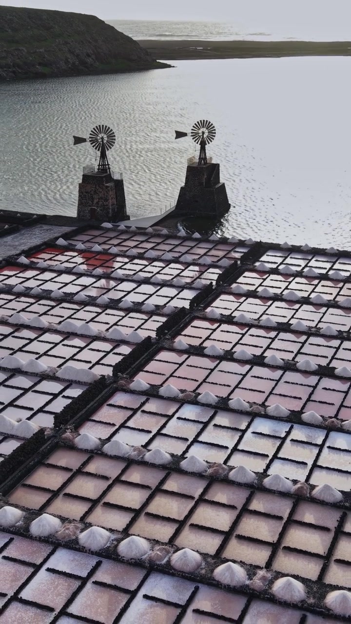 Salt fields in Lanzarote, Spain with windmills and water view